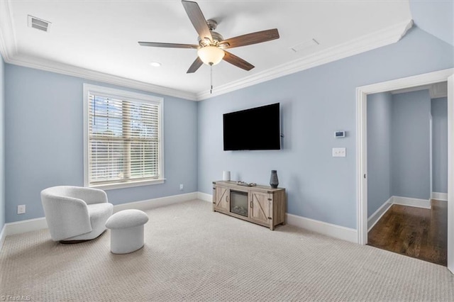 living area featuring carpet floors, ceiling fan, and crown molding