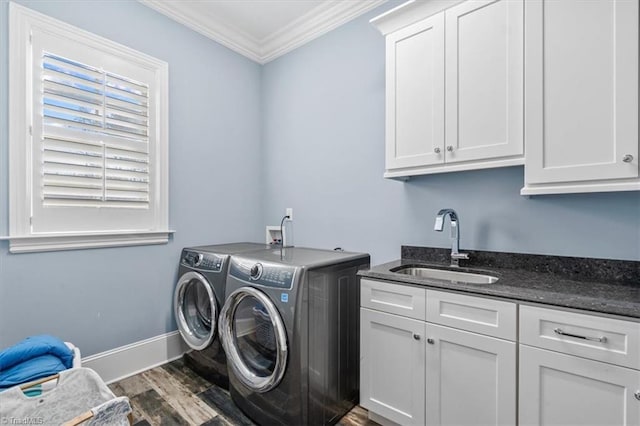 laundry area with cabinets, ornamental molding, dark wood-type flooring, sink, and separate washer and dryer