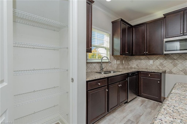 kitchen featuring sink, tasteful backsplash, appliances with stainless steel finishes, light stone countertops, and light hardwood / wood-style floors