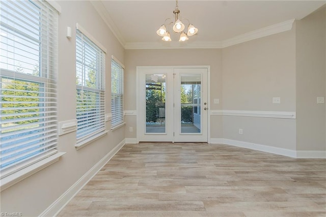 entryway with an inviting chandelier, ornamental molding, and light hardwood / wood-style floors