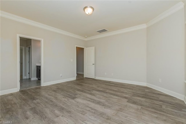 empty room featuring hardwood / wood-style flooring and crown molding