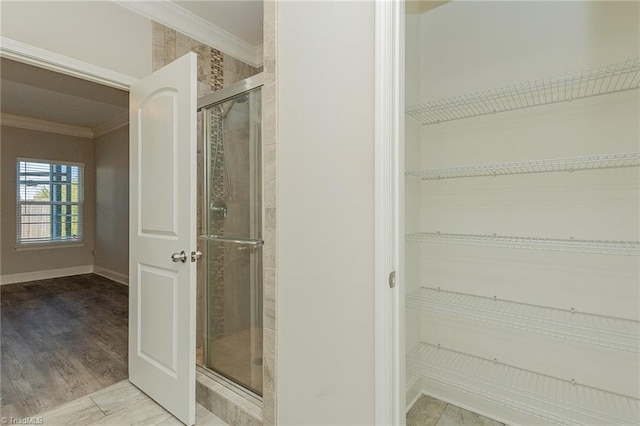 bathroom featuring crown molding, walk in shower, and hardwood / wood-style flooring