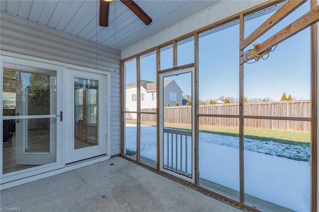 unfurnished sunroom featuring ceiling fan