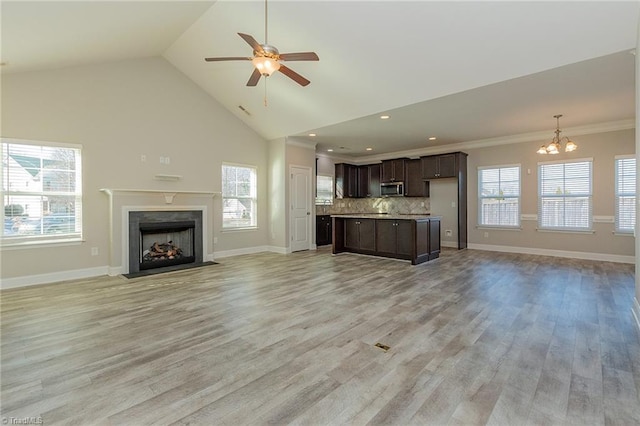 unfurnished living room featuring a healthy amount of sunlight, a high end fireplace, and light hardwood / wood-style flooring