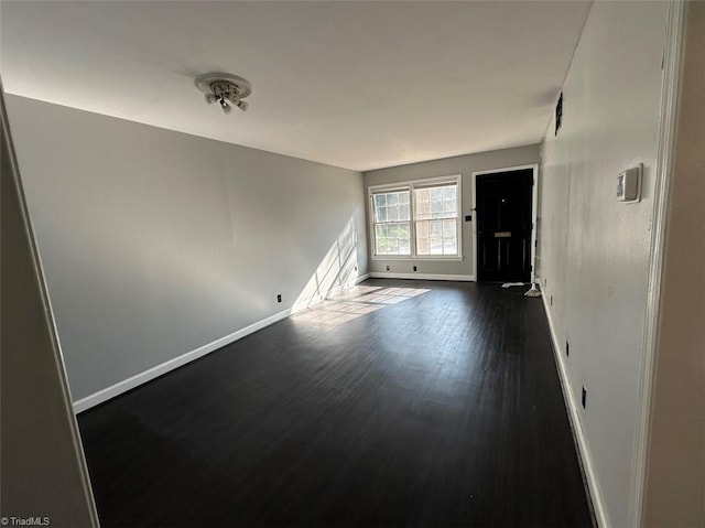 unfurnished room featuring dark wood-type flooring