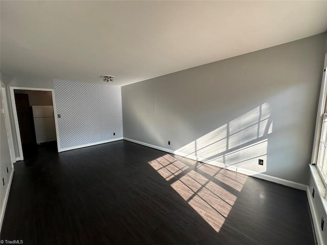 unfurnished room with dark wood-type flooring