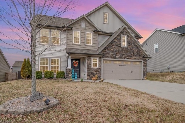 view of front facade featuring board and batten siding, concrete driveway, a yard, a garage, and stone siding