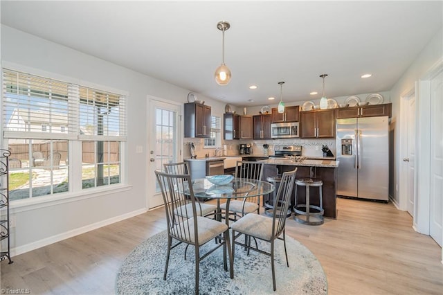 dining area featuring light wood finished floors, recessed lighting, and baseboards