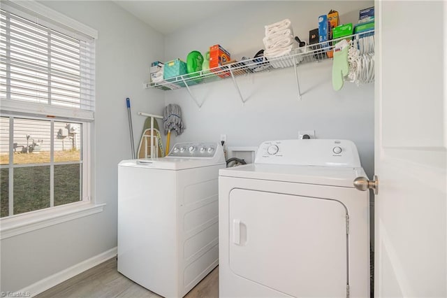 laundry room featuring baseboards, light wood-style floors, laundry area, and washer and clothes dryer