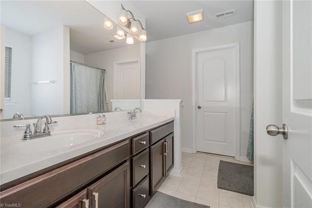 full bath featuring tile patterned floors, double vanity, visible vents, and a sink