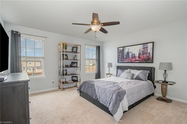 bedroom with ceiling fan, baseboards, and light carpet