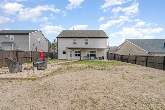 rear view of house with a patio area, a yard, and a fenced backyard