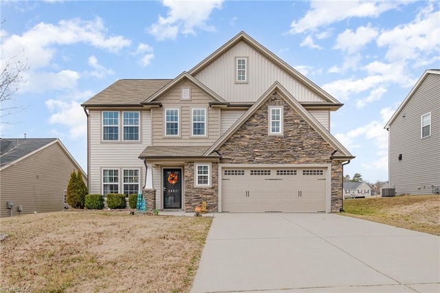 craftsman-style home featuring stone siding, an attached garage, concrete driveway, and central air condition unit