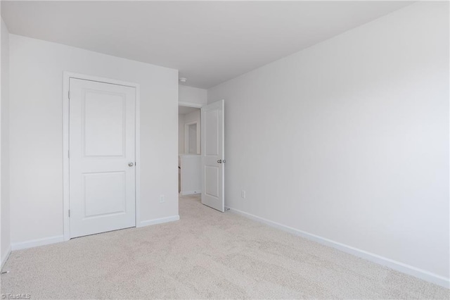 unfurnished bedroom featuring light carpet