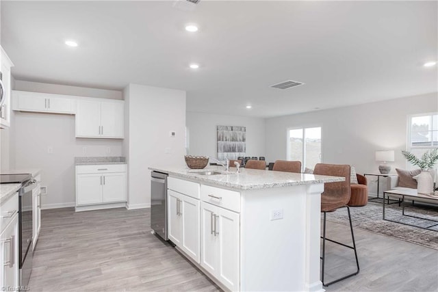 kitchen featuring stainless steel appliances, a kitchen island with sink, sink, and white cabinets