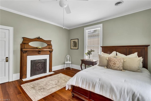 638 N Spring St, Winston-Salem, NC 27101 - bedroom with ornamental molding, baseboards, a tiled fireplace, wood finished floors, and a ceiling fan