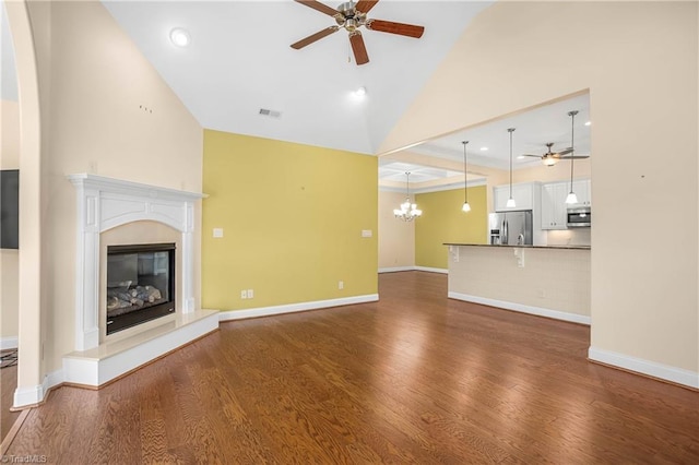 unfurnished living room featuring dark hardwood / wood-style flooring and ceiling fan with notable chandelier