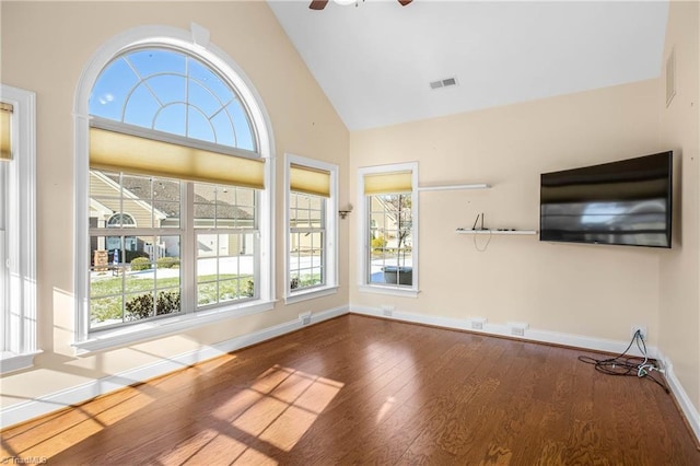 unfurnished living room featuring high vaulted ceiling, ceiling fan, and dark wood-type flooring