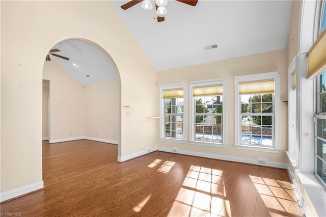 unfurnished room with a healthy amount of sunlight, high vaulted ceiling, and wood-type flooring