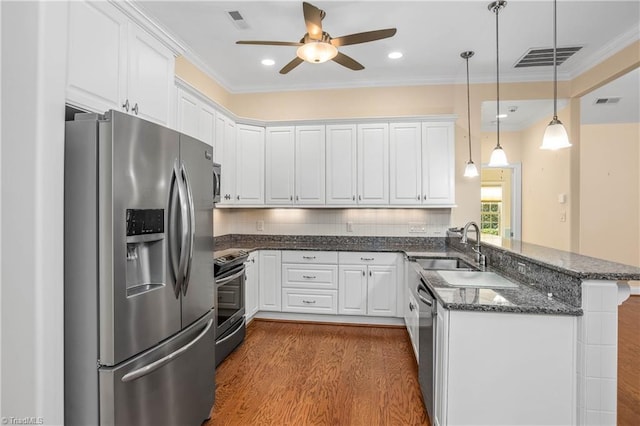 kitchen with appliances with stainless steel finishes, hanging light fixtures, kitchen peninsula, ceiling fan, and white cabinets