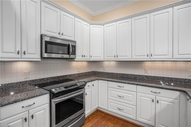 kitchen featuring stainless steel appliances, ornamental molding, and white cabinetry