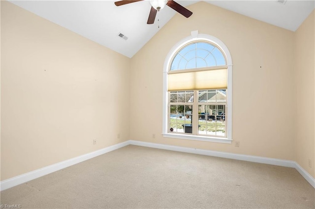 empty room with ceiling fan, vaulted ceiling, and carpet flooring