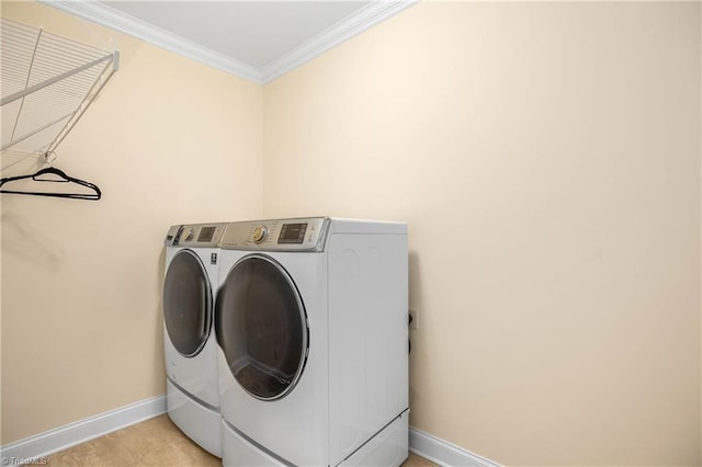 clothes washing area featuring ornamental molding, separate washer and dryer, and light tile patterned floors