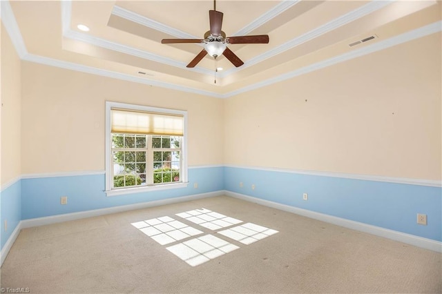 unfurnished room with ornamental molding, light colored carpet, and a tray ceiling