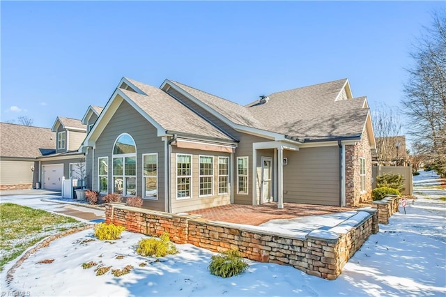 snow covered house featuring a garage