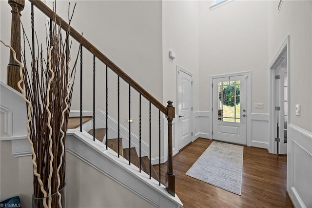 2590 Mccullum Ct, Browns Summit, NC 27214 - entrance foyer featuring wood finished floors, wainscoting, stairs, a decorative wall, and a towering ceiling