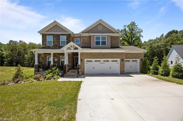 2590 Mccullum Ct, Browns Summit, NC 27214 - craftsman house featuring concrete driveway, a front lawn, a porch, a garage, and stone siding