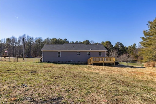 back of property featuring a deck and a lawn