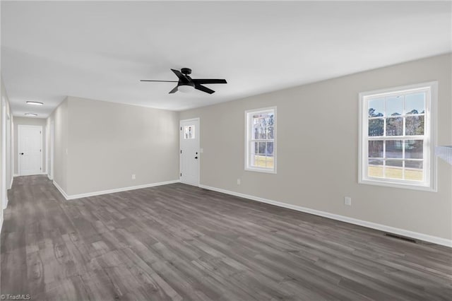 empty room with ceiling fan and dark hardwood / wood-style floors