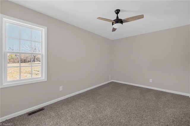 carpeted spare room featuring ceiling fan and a wealth of natural light