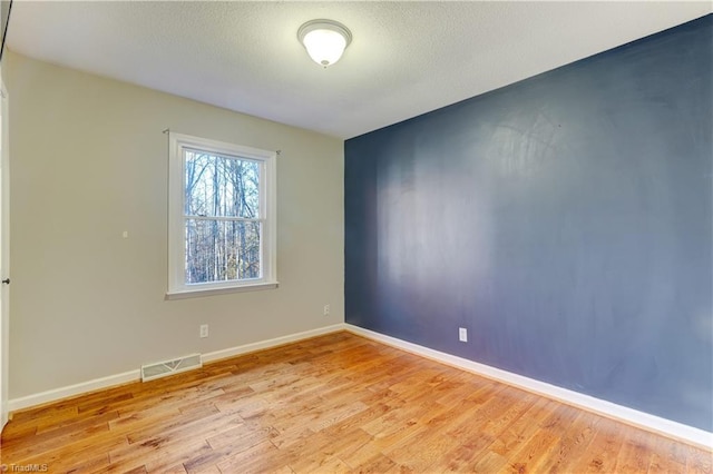 empty room featuring light hardwood / wood-style floors and a textured ceiling