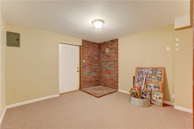 unfurnished room with carpet flooring, brick wall, and electric panel