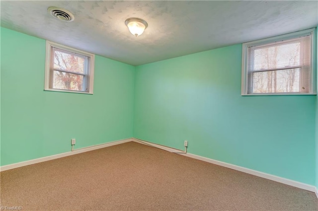 unfurnished room featuring carpet floors and a wealth of natural light