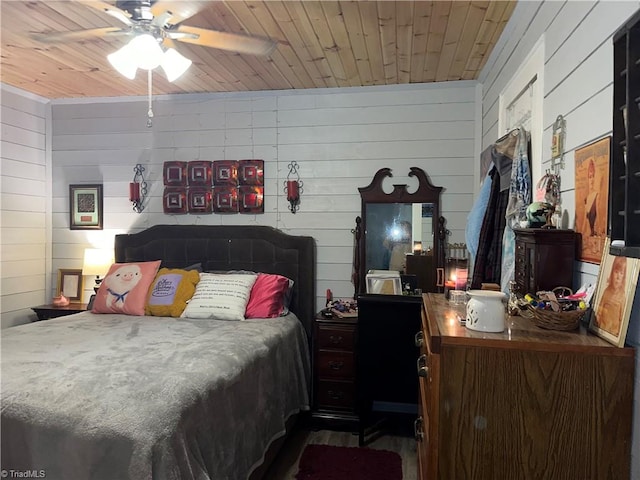 bedroom featuring ceiling fan, wooden walls, and wood ceiling