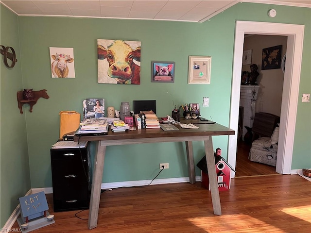 home office featuring a fireplace, wood-type flooring, and ornamental molding