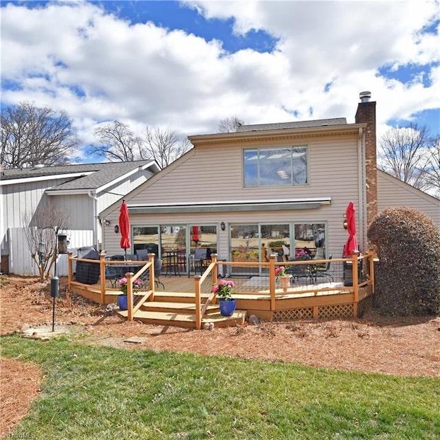 back of property with a wooden deck and a chimney