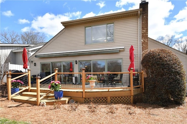 rear view of house with a wooden deck and a chimney