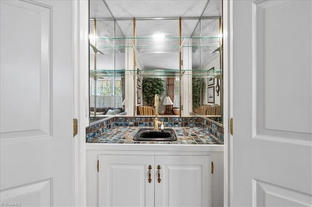 bar with white cabinets and sink