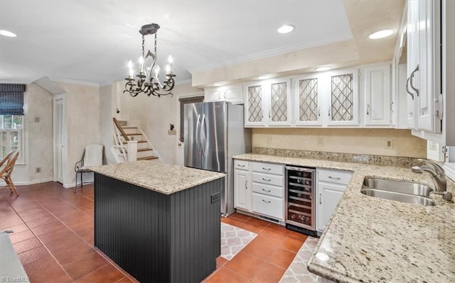 kitchen featuring wine cooler, a center island, white cabinets, stainless steel fridge, and pendant lighting