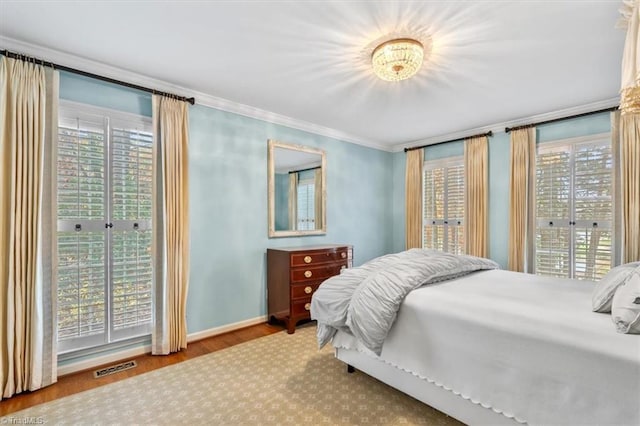 bedroom featuring light wood-type flooring and crown molding