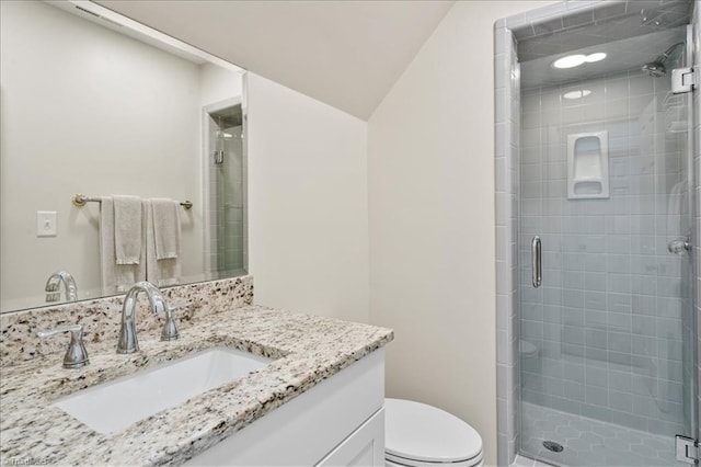 bathroom featuring toilet, vanity, vaulted ceiling, and walk in shower