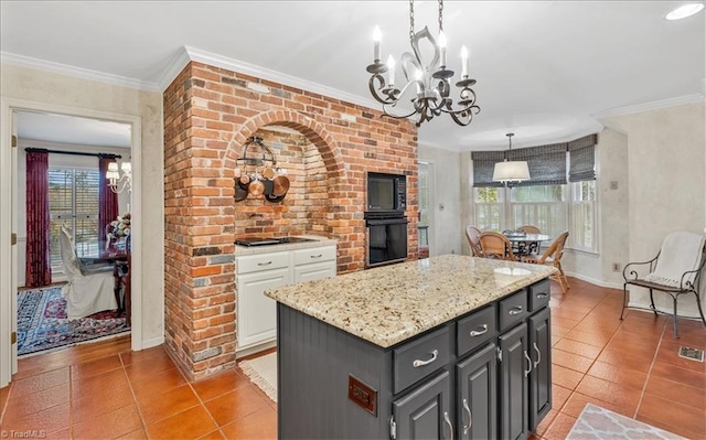 kitchen with a center island, white cabinets, black appliances, ornamental molding, and pendant lighting