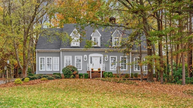 cape cod home featuring a front yard