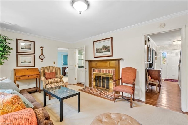 living room with a fireplace, light hardwood / wood-style flooring, and crown molding