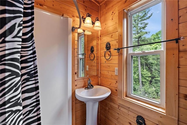 bathroom with sink and wooden walls