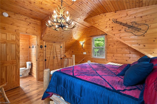 bedroom with hardwood / wood-style floors, wood walls, wood ceiling, and connected bathroom